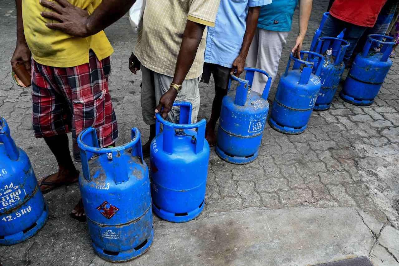 Des personnes font la queue pour acheter des bouteilles de gaz (GPL) à Colombo le 31 décembre 2021, alors que des pénuries de produits de première nécessité frappent l'île suite à une grave pénurie de devises étrangères pour financer les importations.